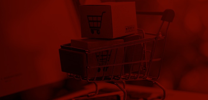 Online shopping concept with cart full of boxes on top of laptop computer